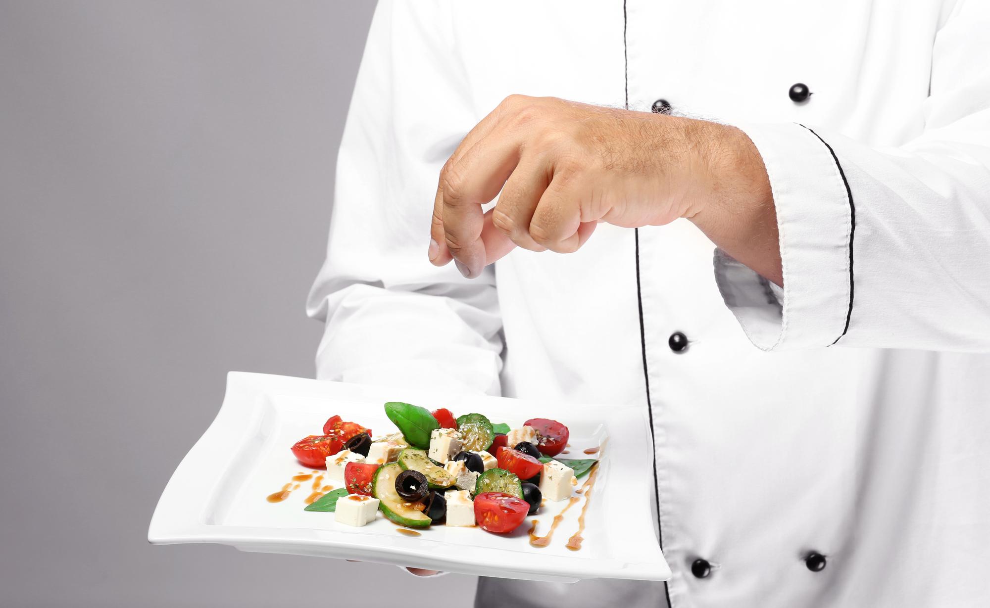 Chef preparing plated dish in clean kitchen